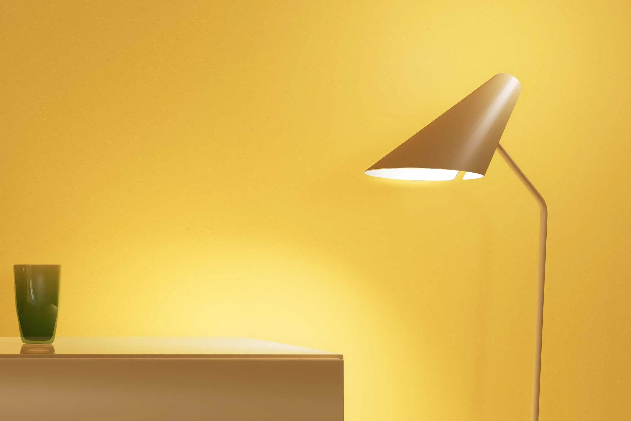 Dining area, close-up of lamp in front of wall area painted in a yellow colour shade from Sto’s Inte